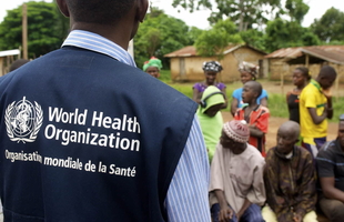 A WHO officer is talking to a group of people, Africa, 2014.