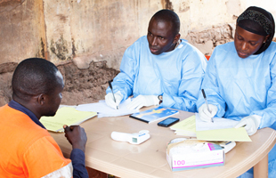 WHO Ebola vaccine trial team at a follow-up session with a participant in the trial, Guinea