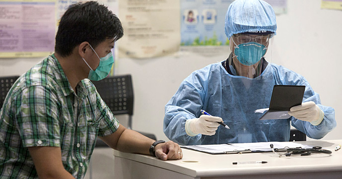 A health worker from Hong Kong's Department of Health demonstrates the protocol for quarantining a passenger for Middle East respiratory syndrome (MERS), on a government employee during a set up demonstation for Hong Kong Chief Executive Leung Chun-ying, at Hong Kong airport, Hong Kong SAR.