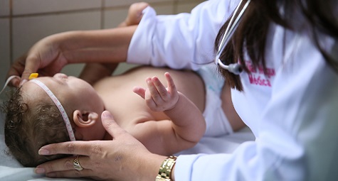 Woman measures baby's head for microcephaly.